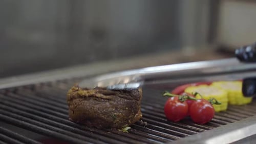 Chef Preparing Tasty Meat on the Grill, Turning It with Tongs