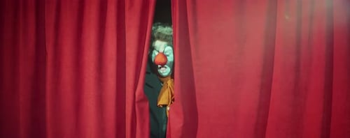 Clown Peeking through Stage Curtains and Performing Comedy
