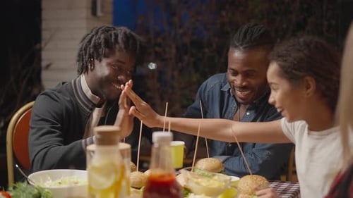 Friends share meal outdoors at night