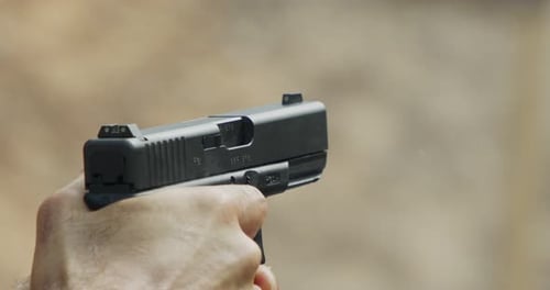 Pistole schießt Kugeln in Zeitlupe. Handfeuerwaffen im Schießstand