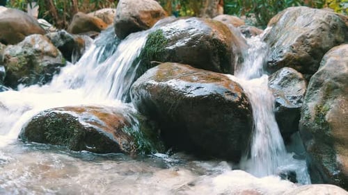 Peaceful Waterfall Cascading Over Mossy Rocks
