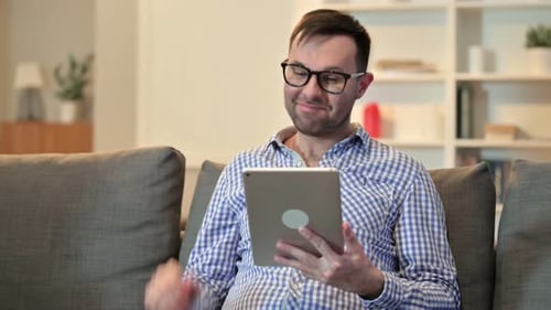 Man Using Tablet for Video Call at Home