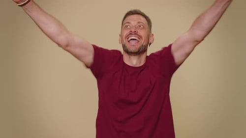 Man Cheers in Excitement Raising Arms in the Air