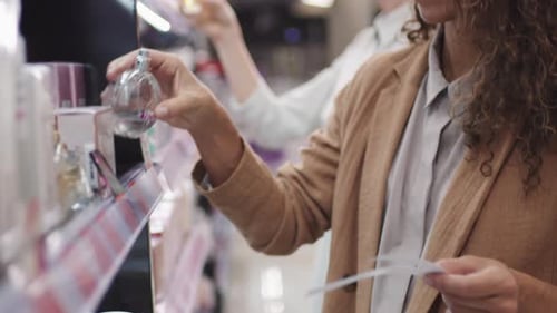 Pretty Woman Choosing Perfume In Beauty Shop