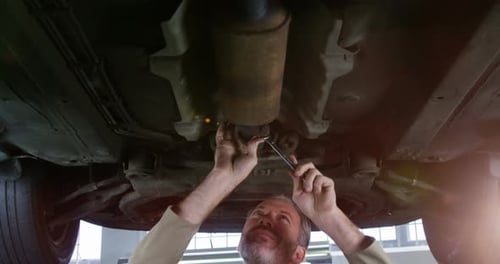 Mechanic Working Under Car with Wrench
