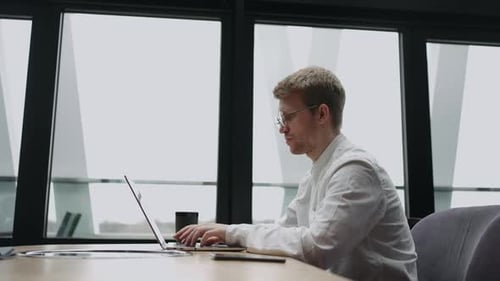 Freelancer Programmer or Translator is Working with Laptop in Cafe or Coworking Space Typing Text in