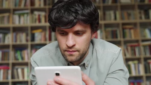 Young Adult Man Using Tablet Indoors Close Up