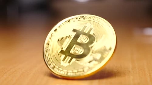 Golden Bitcoin Spins on Wooden Table