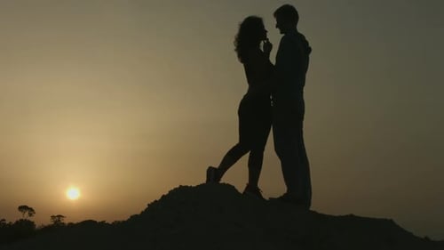 Silhouetted Couple Embraces at Golden Sunset