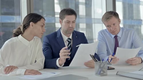 Executive Business People Sharing Information Through Documents on Office Table