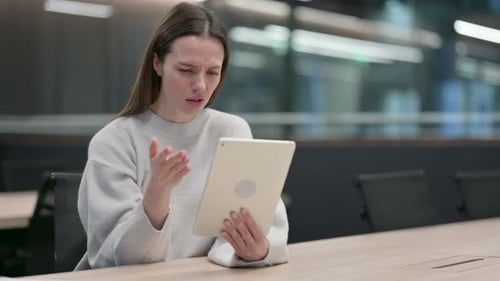Confused Young Woman Using Tablet in Modern Office