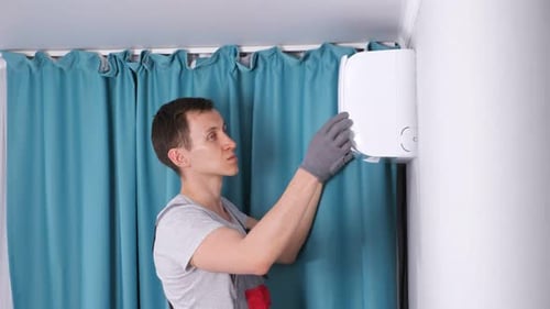 Technician Repairs Air Conditioner Unit in Home