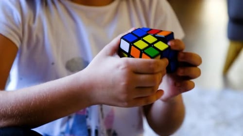 Child Manipulates Rubik's Cube Puzzle
