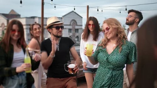 Cheerful Friends Enjoy Summer Evening Roof Party at Terrace Dancing Drinking Alcohol