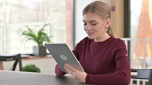 Digital Tablet Use By Beautiful Young Woman in Office