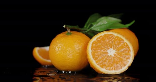 Whole Tangerines with Leaves and Slices Slowly Rotate.