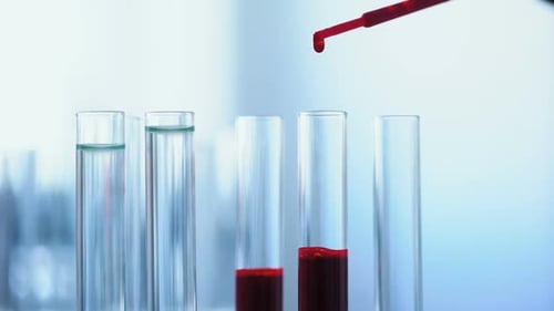 Pipette Drips Red Fluid Into Test Tubes