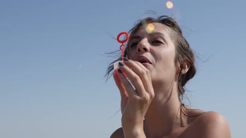 Schöne kaukasische brünette Frau spielt mit Seifenblasen im Freien 4K 2160p 30fps UltraHD-Aufnahmen