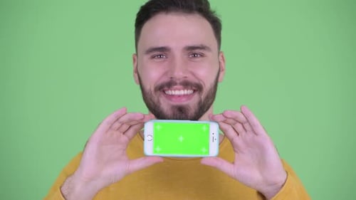 Smiling Young Adult Holding Chroma Key Smartphone