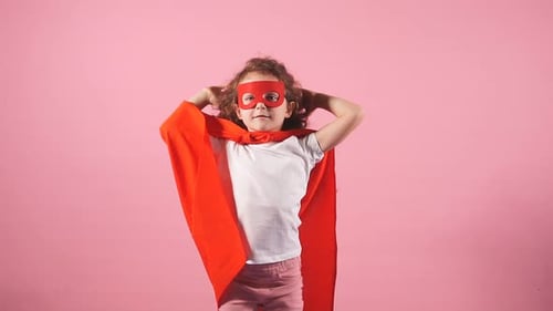 Adorable Girl Wearing Superhero Cape and Mask Posing