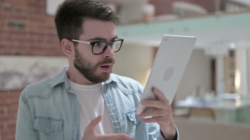 Young Man Celebrates While Using Tablet