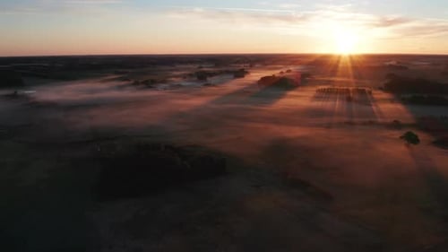 Majestic Aerial View of Misty Fields Taken During Sunrise