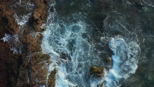 Waves Crashing on Rocky Coastline From Above