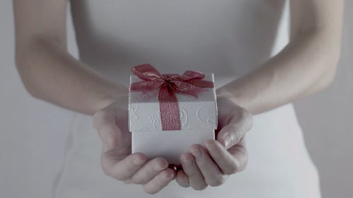 Woman Holds Gift Box with Red Bow