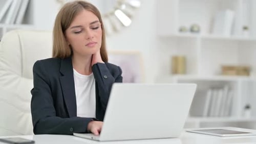 Tired Businesswoman with Laptop Having Neck Pain in Office