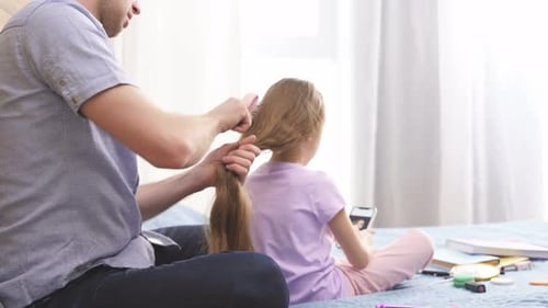 Loving Father Brushing Daughter's Hair in Bedroom