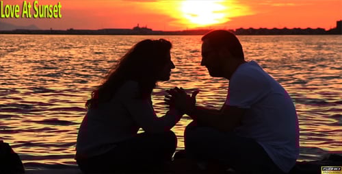 Silhouetted Couple Holding Hands at Sunset by Ocean