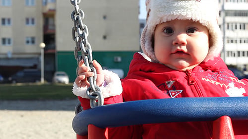 Cute Infant Swings at a City Playground