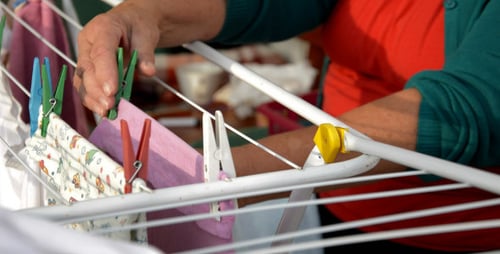 Adult Hanging Laundry on Clothes Drying Rack