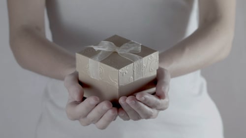 Person Holds Decorated Brown Gift Box