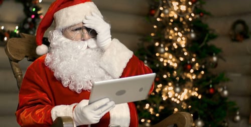 Santa Claus Using Tablet Device in Rocking Chair