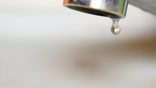 Close Up of Water Dripping from a Chrome Faucet