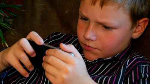 Focused Boy Using Mobile Device Indoors
