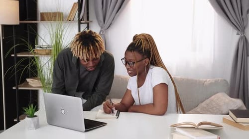 Young Adults Studying Together at Home with Laptop