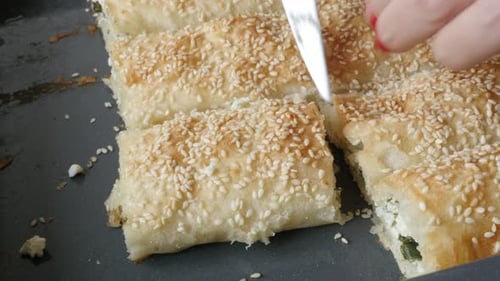 Cutting baked rolled thin sheets of dough with filling 4K 2160p 30fps UHD footage - Arranging filo
