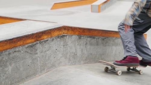 Skater Practicing in the Autumn Concrete Skate Park Making Tricks and Rides in Ramp