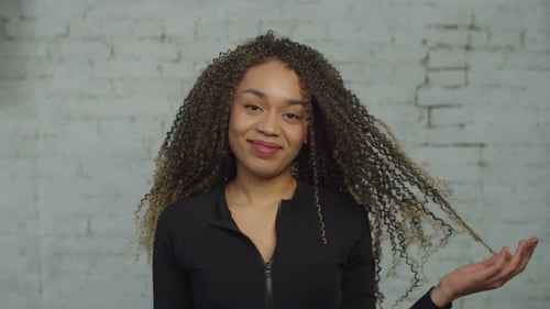 Smiling Woman with Curly Hair Posing Indoors