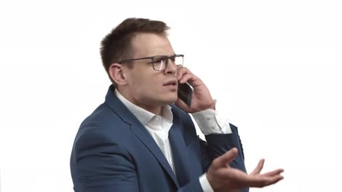 Upset Man Talking on Phone Wearing Business Suit