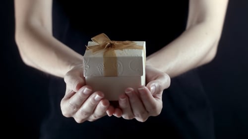Woman Holds Gift Out in Hands