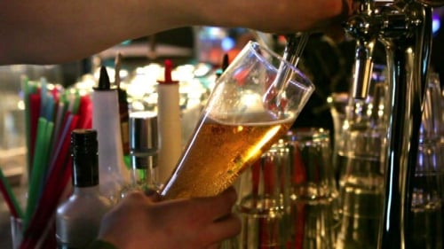 Bartender Pouring Draft Beer into Glass at Bar