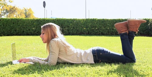 Woman Using Laptop Outdoors on Green Lawn