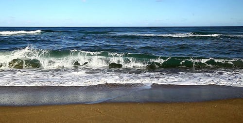 Waves Crashing on Beach Sand on Sunny Day