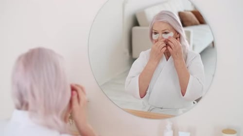 Senior Woman Applying Eye Patches at Home