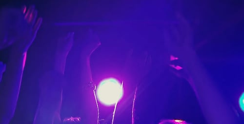 Silhouetted Crowd Waving Hands at Concert Stage