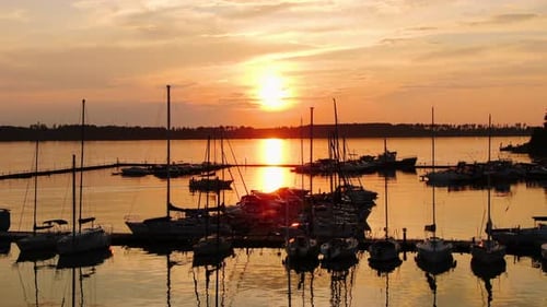 A Sailing Boat Enters the Pier Against the Backdrop of the Sunset. Silhouette of the Ship Against