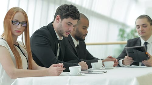 Diverse Team Discusses Documents at Modern Meeting Table